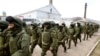 Armed men, believed to be Russian servicemen, walk outside a Ukrainian military base in Perevalnoye, near the Crimean city of Simferopol on March 14.