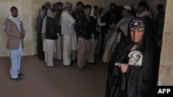 An Afghan woman who was repatriated from Iran looks on with other returnees at a provincial refugee agency premises in Herat, in eastern Afghanistan, in 2012.