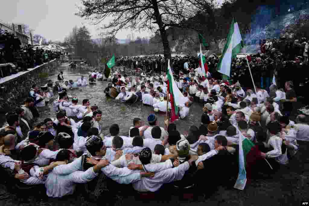 De Bobotează, în orașul bulgar Kalofer, dansuri tradiționale pe apele înghețate ale rîului Tundja. (AFP/Dimitar Dilkoff)