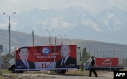 A woman walks past election banners in the capital, Bishkek, on October 1.