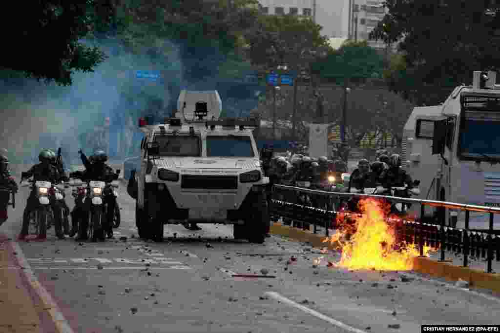 Members of the national police force clash with protesters during an antigovernment demonstration in Caracas on January 23.
