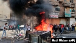 Anti-government protesters set fire and block roads in Baghdad, Iraq, Wednesday, Oct. 2, 2019. 