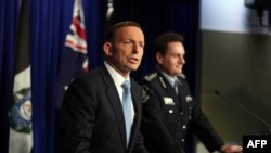 Australian Prime Minister Tony Abbott (left) speaks at a joint press conference with Australian Federal Police Commissioner Tony Negus at the Australian Federal Police headquarters in Canberra on July 25 .