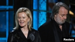 Two ABBA members, Anni-Frid Lyngstad and Benny Andersson, celebrate their induction into the Rock and Roll Hall of Fame.