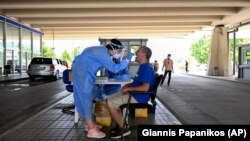 Грција - Здравствен работник зема брис за ковид од турист.