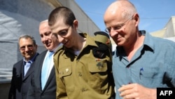 Israeli soldier Gilad Shalit (center) being hugged by his father Noam (right) for the first time in five years on October 18.