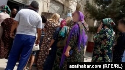 People line up outside a grocery in the Lebap region.