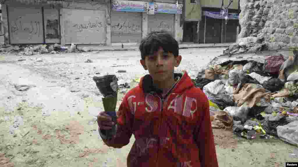 A boy holds mortar shrapnel in a handout picture taken by a Syrian National Council member in Karm Al Zaytoon, a neighborhood of Homs, on February 23. (REUTERS/Moulhem Al-Jundi/Handout)