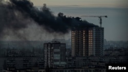 Smoke rises over a residential building after a Russian missile and drone strike in Kyiv on December 29.