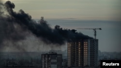 Дим піднімається над житловим будинком після російського удару 29 грудня, Київ