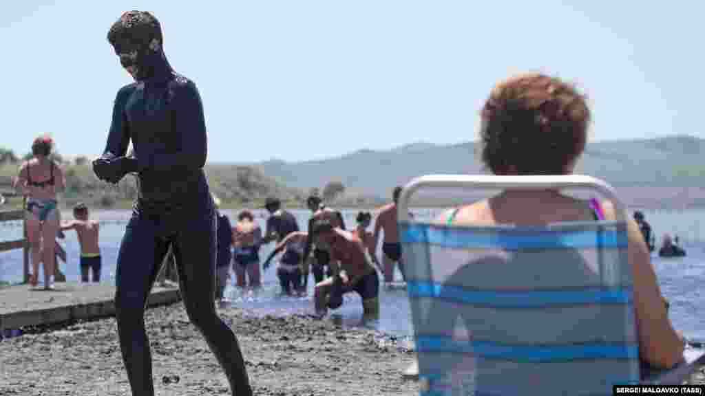 Отдыхающие во время приема грязевых ванн на озере Чокрак в поселке Курортное Ленинского района, Крым