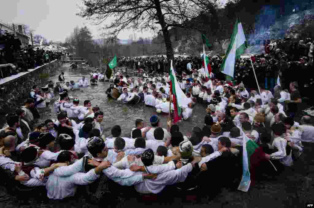Men dance in the icy winter waters of the Tundzha River in the Bulgarian town of Kalofer as part of Epiphany Day celebrations. As a tradition, an Eastern Orthodox priest throws a cross in the river and it is believed that the one who retrieves it will be healthy through the year, as well as all those who dance in the icy waters. (AFP/Dimitar Dilkoff)