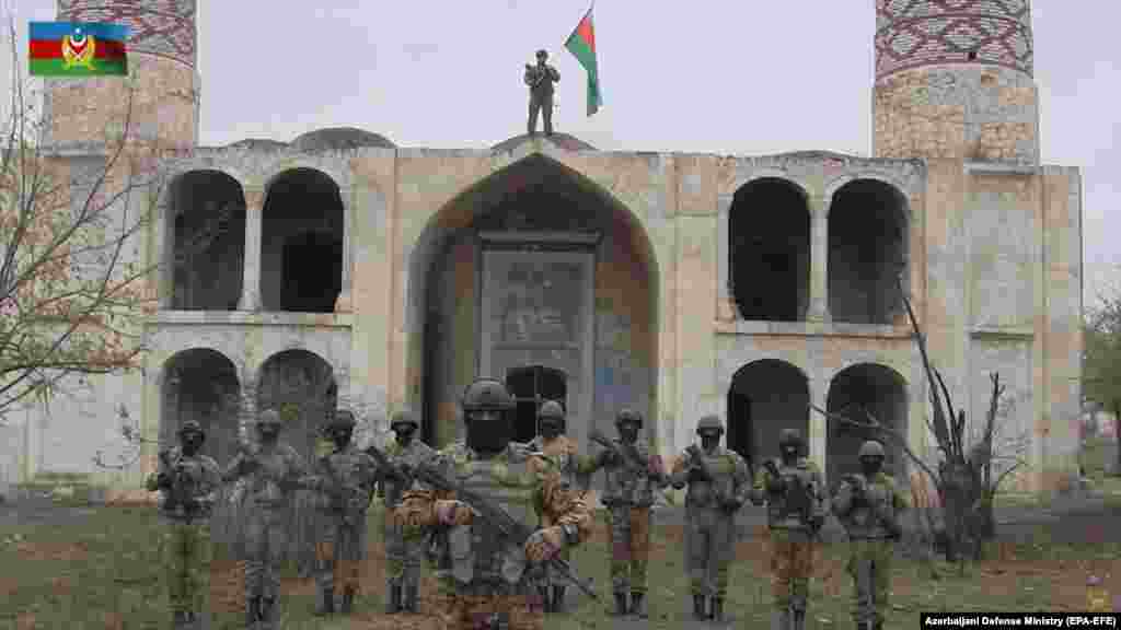 Azerbaijani servicemen pose in front of the Agdam mosque in a propaganda video after the town returned to Azerbaijani control on November 20. Lohr says he is &quot;curious how it will look now&quot; and wonders &quot;what the Azerbaijanis will do with [Agdam].&quot; Thousands of displaced Azerbaijanis have vowed to return and rebuild it.