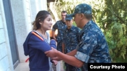 One of several undated photos of Gulnara Karimova -- apparently under house arrest and being restrained by security troops -- released in September by Ryan Locksley.