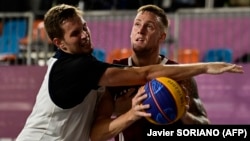 Russia's Aleksandr Zuev (left) fights for the ball with Latvia's Karlis Lasmanis during the men's gold medal 3x3 basketball final match during the Tokyo 2020 Olympic Games in July 2021.
