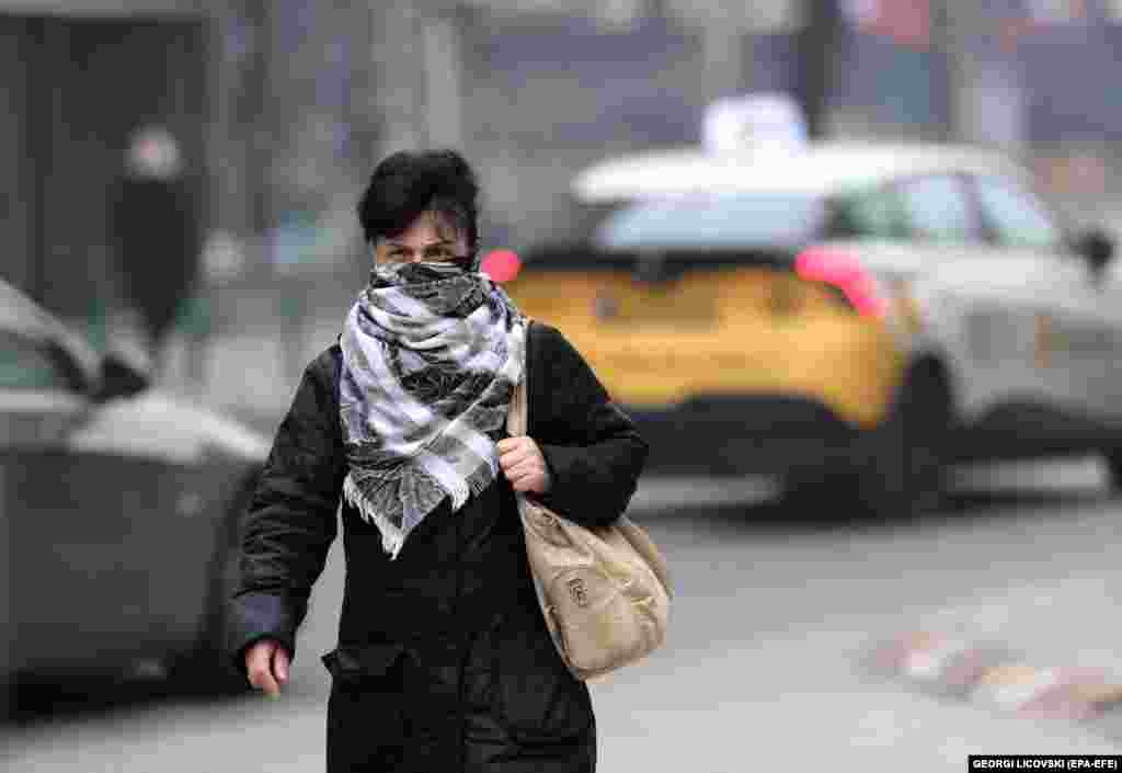 A woman wears a protective scarf as she walks through the smoggy streets of North Macedonia&#39;s capital, Skopje.&nbsp;