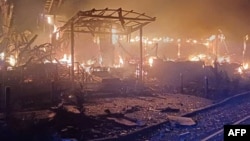 A handout photograph released by the Ukrainian Emergency Service on December 25 shows a damaged building on fire following an apparent air attack on the Odesa region.