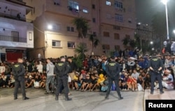 Policija prati migrante u privremeni kamp u španskoj enklavi Seuta, 18. septembar 2026.