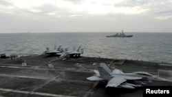 File photo shows US fighter jets on an aircraft carrier in the Strait of Hormuz.