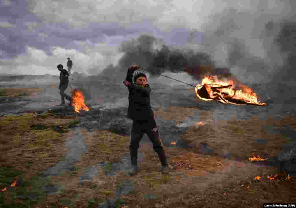 A youth spins a flaming tire as part of a tradition marking the upcoming first day of Lent in the Eastern Orthodox Church calendar, in the Romanian village of Poplaca on March 10.&nbsp;(AFP/Daniel Mihailescu)