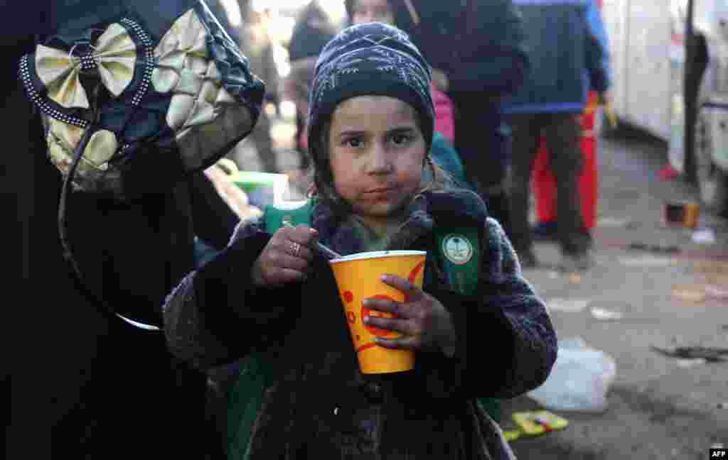 A Syrian girl who was evacuated from the last rebel-held pockets of Syria's northern city of Aleppo eats upon arriving in the opposition-controlled Khan al-Assal region, west of the embattled city. (AFP/Baraa Al-Halabi)
