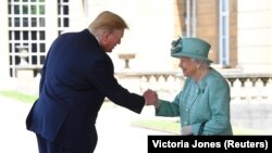 Queen Elizabeth II greets U.S. President Donald Trump as he arrives for the ceremonial welcome at Buckingham Palace on June 3.