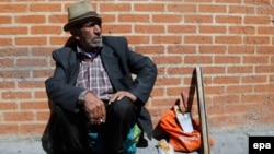 An Iranian laborer sits next to his tools on a Tehran street in April. Despite the nuclear deal, the recovery of an economy deeply affected by sanctions and years of mismanagement will take some time. 