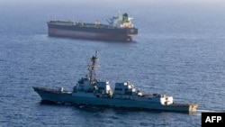 This US Navy handout photo released on May 7 by US Central Command Public Affairs shows the Arleigh Burke-class guided-missile destroyer USS Rafael Peralta implementing a maritime blockade against the Iran-flagged crude oil tanker vessel.