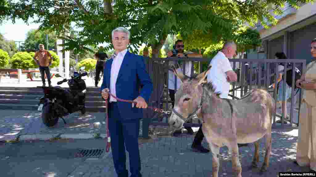 Avokati i njohur kosovar, Arianit Koc me një gomar pranë ndërtesës së Kuvendit të Kosovës në Prishtinë, për të protestuar ndaj mungesës së vullnetit të deputetëve për ta bërë kuvendin e ri, 3 korrik 2025.Ligjvënësit kosovarë e themeluan Kuvendin pas disa dhjetëra takimeve përgjatë nëntë muajve të vitit, i cili u shpërbë pothuajse mënjeherë pas dështimit për ta votuar një qeveri të re, dhe Kosova shkoi në zgjedhje të parakohshme parlamentare më 28 dhjetor.