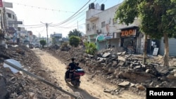 Un palestinian conduce o motocicletă pe o stradă puternic avariată în urma operațiunii militare israeliene în Jenin. 6 septembrie 2024.