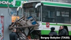 Police say the crash occurred when a car hit the bus and pushed it into a bus stop.