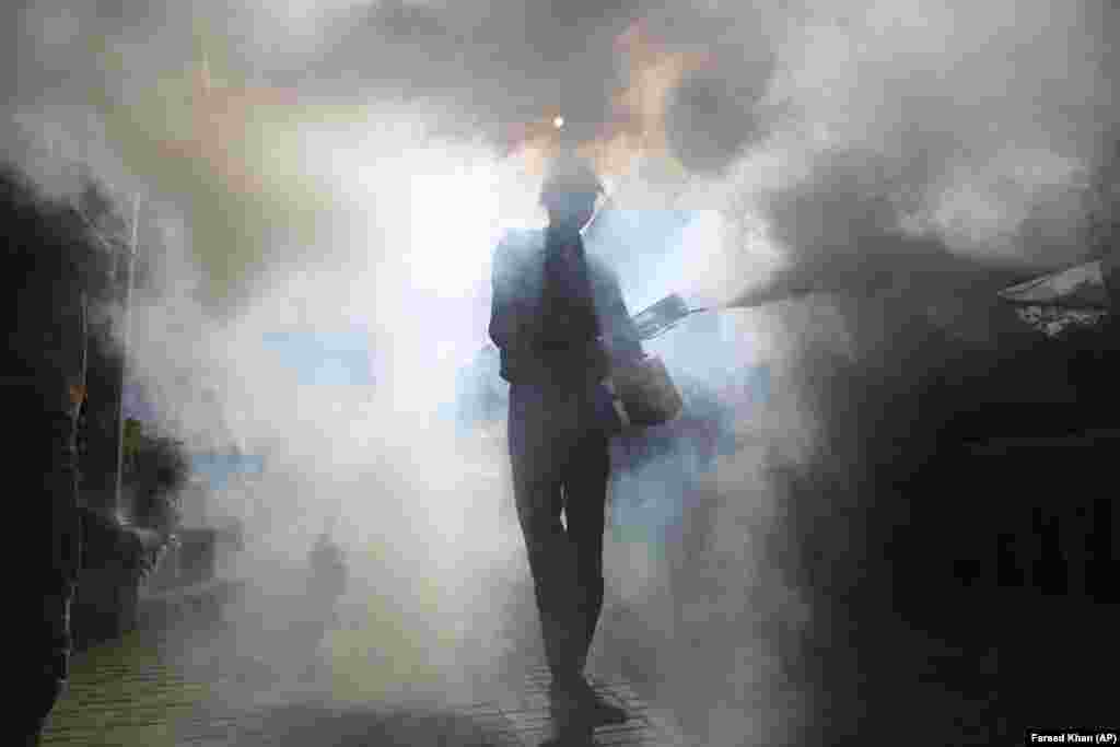 A volunteer disinfects the Karachi Press Club building in an effort to contain the outbreak of the coronavirus, in Karachi, Pakistan. (AP/Fareed Khan)