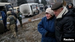 Жителі Дебальцева спостерігають, як їхні родичі сідають в автобуси, які вивезуть їх з міста, 6 лютого 2015 року