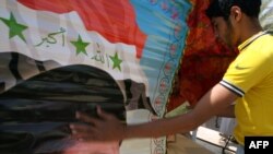 An Iraqi man hangs a poster in support of the Sadrist movement with a picture of Shi'ite cleric Moqtada al-Sadr.