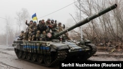 Ukrainian soldiers ride atop a tank in the Chernihiv region on April 2.