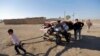 Kurdish Syrian refugees fleeing an Islamic State offensive carry their belongings after crossing the Turkish-Syrian border, near the southeastern town of Suruc in Sanliurfa province on September 26