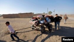 Kurdish Syrian refugees fleeing an Islamic State offensive carry their belongings after crossing the Turkish-Syrian border, near the southeastern town of Suruc in Sanliurfa province on September 26