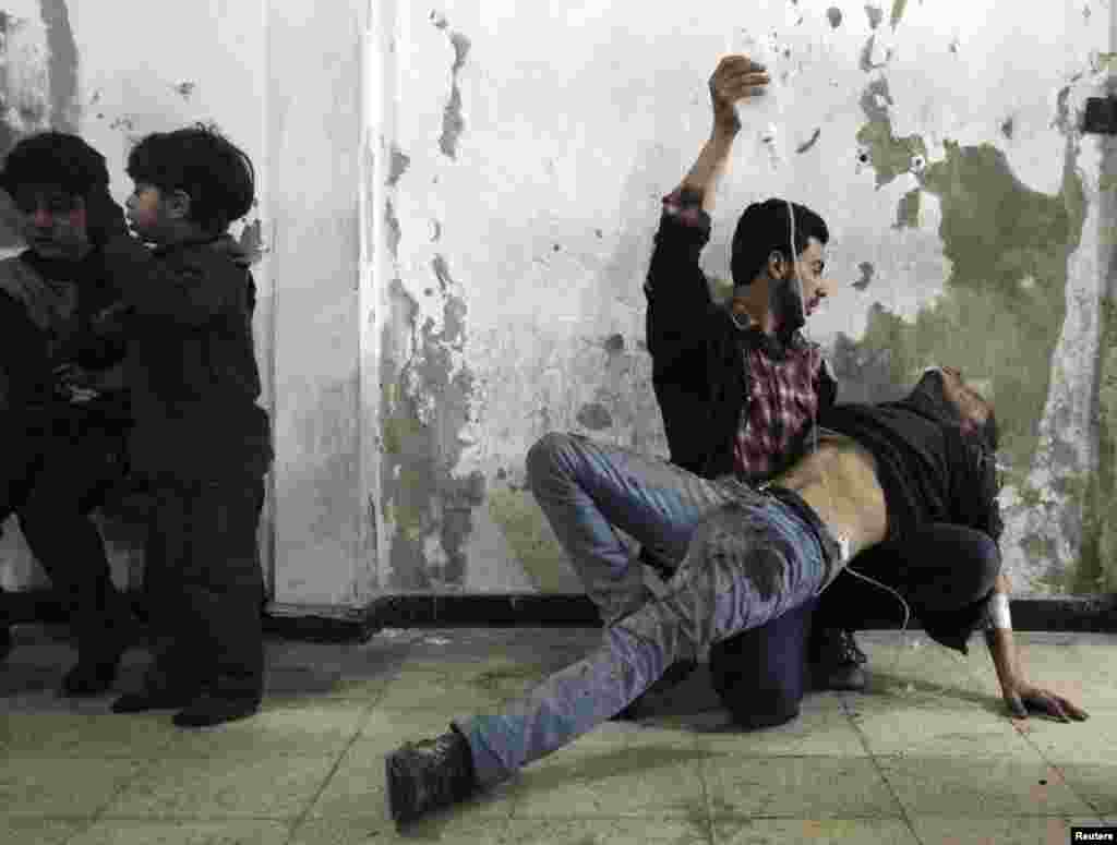 A man gives medical assistance to an injured man as two wounded children wait nearby at a field hospital after what activists said was an air strike by government forces in the Douma neighborhood of Damascus. (Reuters/Mohammed Badra)