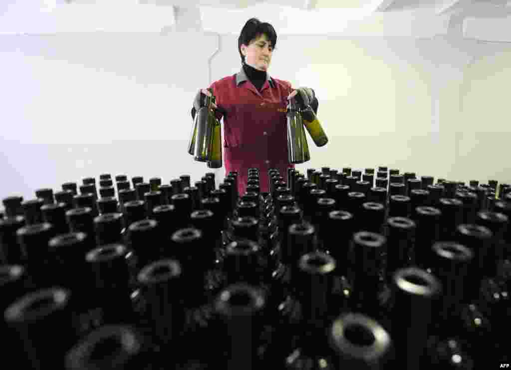 An employee tends to bottles at a winery in Tbilisi. Georgian officials recently held talks in Moscow to make preliminary arrangements for the lifting of a Russian trade embargo on Georgian wine and mineral water. (AFP/Vano Shlamov)