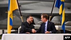 Volodimir Zelenski și premierul suedez Ulf Kristersson, la baza aeriană din Uppsala, Suedia, mai 2026. Ucraina a anunțat planuri pentru achiziția a 20 de avioane de luptă Gripen de ultimă generație, în timp ce Suedia urma să doneze 16 aparate mai vechi.