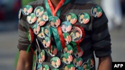  A Pakistani supporter of opposition politician Imran Khan is seen wearing badges of the politician during a protest in front of the parliament building in Islamabad, August 20, 2014.