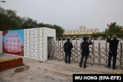 Foreign journalists take photos and video outside the location of a suspected internment facility for Uyghurs and other groups in Xinjiang on April 22, 2021.