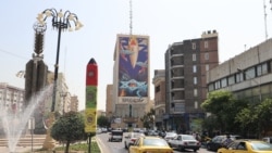 ترافیک در یک خیابان تهران که روی یکی از ساختمان‌های آن پوستری بزرگ چسبانده شده است با این شعار: «موشک به میان دیوها افتاده» 