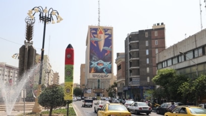 ترافیک در یک خیابان تهران که روی یکی از ساختمان‌های آن پوستری بزرگ چسبانده شده است با این شعار: «موشک به میان دیوها افتاده» 