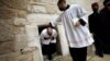 دو کشیش در حال بیرون آمدن از کلیسای مهد، بیت‌اللحم، ۲۴ دسامبر ۲۰۲۰