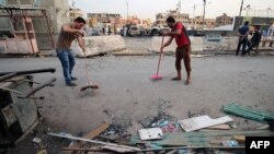 Punëtorët duke e pastruar vendin ku kishte ndodhur një sulm i mëparshëm vetëvrasës në Sadr City të Bagdadit