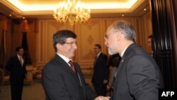 Iranian Foreign Minister Ali Akbar Salehi (right) greets his Turkish counterpart Ahmet Davutoglu.
