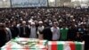 An Iranian cleric prays over the coffins of the victims of the Zahedan attacks during a mass funeral in the southeastern Iranian city on July 17.