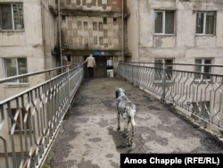 Мужчина заходит в многоэтажку советских времен в северном пригороде Тбилиси.