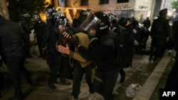 Police try to disperse protesters as they participate in a demonstration against the government's decision to delay EU membership talks, near the parliament building in downtown Tbilisi on November 29.